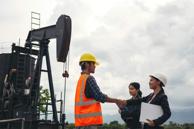 engineering_team_stands_beside_working_oil_pumps_with_sky_1_1_scaled_2